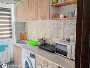 a kitchen counter with a microwave and a sink at 4 Rooms Apartment in Tulcea