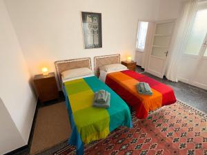 two beds with colorful sheets in a room at Casa Mariuccia in Ponzone