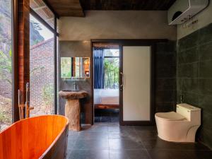 łazienka z toaletą i umywalką oraz sypialnia w obiekcie Trang An Mountain Resort w mieście Ninh Binh +54 zdjęcia