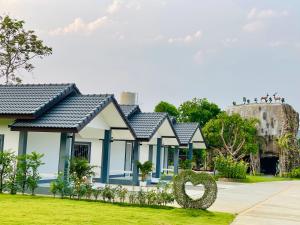 a row of houses in a park with a sculpture at Piang Dao Classic resort in Chiang Dao