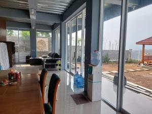 a dining room with a table and some windows at Channel Stay at Machaka Villa Bandungan in Bandungan +36 photos