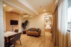 a living room with a couch a table and a chair at Snooze Inn & Suites in Davao City