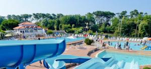 a large pool with a water park with people in it at La Terrasse du Golf in Talmont