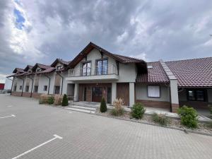 a large house with a parking lot in front of it at Karczma u Jakuba in Domaniów
