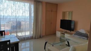a living room with a large window and a television at Double Peach Apartment in Sveti Vlas