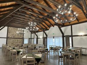 a dining room with tables and chairs and chandeliers at Karczma u Jakuba in Domaniów