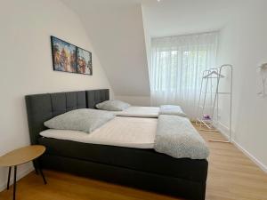 ein Bett mit zwei Kissen darauf in einem Zimmer in der Unterkunft Cozy Apartment in Rösrath in Rösrath