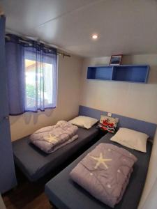 a room with two beds and a window at Mobil-Home le Montourey in Fréjus