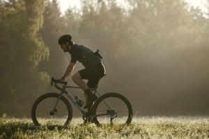 a man riding a bike in a field at Hotel Le Mont Medical & SPA in Świeradów-Zdrój