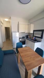 een keuken met een houten tafel en blauwe stoelen bij Sunny Apartment in Ofrínion