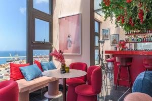 ein Restaurant mit roten Stühlen und eine Bar mit Aussicht in der Unterkunft Gate 9 Tower - Studios & Apartments in Mar Mikhael in Al Mudawwar