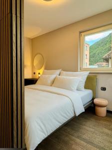 a bedroom with a large white bed with a window at VILLAREJA - Stilvolle ruhige Boutique-Suite mit Terrasse, Designbad und Altstadtblick im Herzen von Bozen in Bolzano