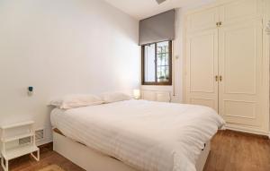 ein weißes Schlafzimmer mit einem großen Bett und einem Fenster in der Unterkunft Pet Friendly Apartment in El Puerto de Santa María