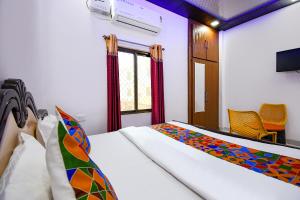 a bedroom with a bed and a window at FabHotel Geeta Bhawan in Ayodhya