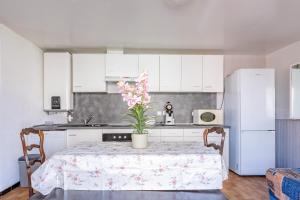 une cuisine avec une table avec un vase de fleurs dessus dans l'établissement Le Robinson - proche plage, à Marseillan 1 autre photo