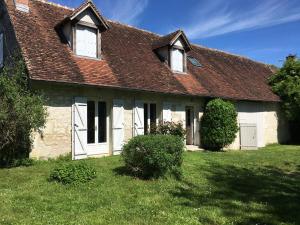 a house with white doors and a brown roof at Longère avec piscine in Couffy