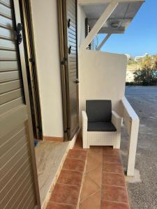 a chair sitting on the porch of a house at Hotel Giglio in Lampedusa