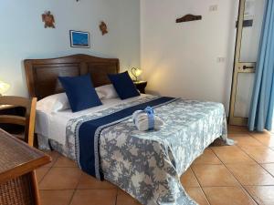 a bedroom with a bed with blue pillows at Hotel Giglio in Lampedusa