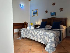 a bedroom with a bed with blue pillows at Hotel Giglio in Lampedusa