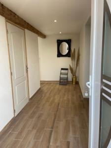 a hallway with a wooden floor and a white door at Maison de campagne in Ribeaucourt