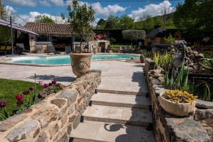 a stone retaining wall next to a swimming pool at La babounette in Jaujac