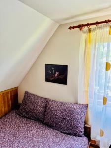 un dormitorio con una cama y una ventana en Hestur Ivo, en Izvoare