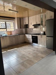 a large kitchen with wooden cabinets and stainless steel appliances at Springbridge Accom in Gaborone