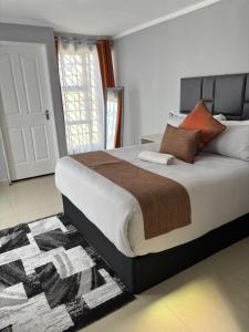 a bedroom with a large bed with a rug at Springbridge Accom in Gaborone