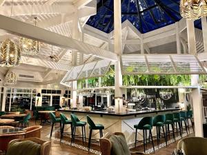 a restaurant with a bar with green chairs at La Terrasse du Golf in Talmont