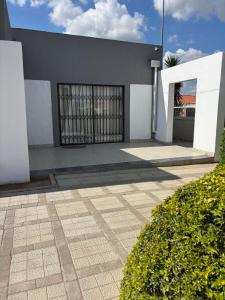 a building with two doors and a courtyard at Springbridge Accom in Gaborone