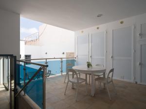 Un comedor con mesa y sillas en un balcón. en La Casa de La Graciosa, en Caleta de Sebo