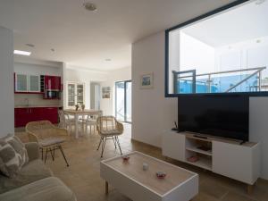 Una sala de estar con un televisor de pantalla plana grande. en La Casa de La Graciosa, en Caleta de Sebo