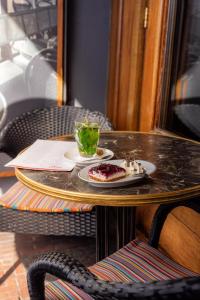 einen Tisch mit einem Teller Essen und einem Drink darauf in der Unterkunft Boutique Hotel Catshuis in Leeuwarden