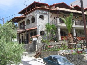 a house with a car parked in front of it at Πανσιόν Άγγελος in Ouranoupoli +7 photos