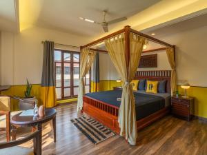 科钦The Hosteller Fort Kochi, Ocean Edge的一间带天蓬床的卧室和一间客厅