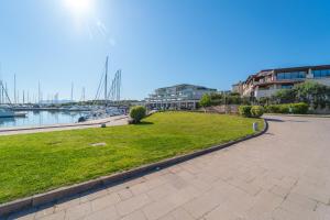 a park next to the water with boats at Tilly by DomusAway in Olbia