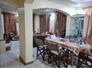 Un comedor y una sala de estar con mesa y sillas. en Villa Jane in Arusha, en Arusha 14 fotos más
