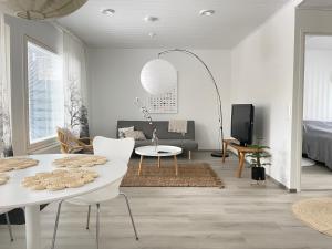 a living room with a white table and a couch at Valoisa uusi kaksio keskellä Suomea in Haapavesi