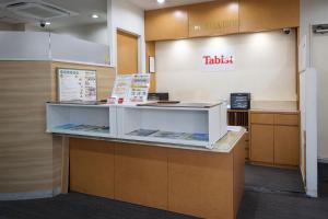 a waiting area of a hotel with a ticket counter at Tabist HotelArflex Tokuyama Station in Shunan
