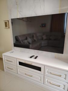 a living room with a couch and a large screen tv at Bumiemas Villa - 2 BEDROOM in Kangar