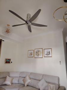a ceiling fan in a living room with a couch at Bumiemas Villa - 2 BEDROOM in Kangar