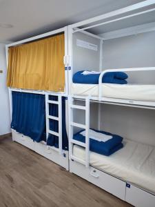 zwei Etagenbetten in einem Zimmer mit Fenster in der Unterkunft Albergue SP 55 by Bossh! Hotels in Santiago de Compostela