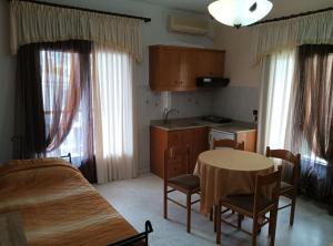 a kitchen with a table and a table and chairs at Πανσιόν Άγγελος in Ouranoupoli