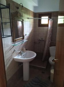 a bathroom with a sink and a toilet at Πανσιόν Άγγελος in Ouranoupoli