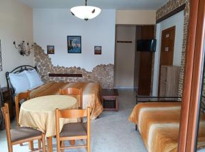 a hotel room with a table and a bed and a room at Πανσιόν Άγγελος in Ouranoupoli