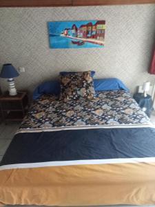 une chambre avec un lit avec un tableau sur le mur dans l'établissement Chambre d hôte, à La Celle-sous-Gouzon