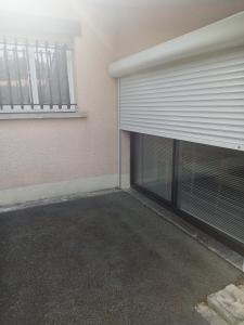 un parking vide à côté d'un immeuble avec garage dans l'établissement Chambre d hôte, à La Celle-sous-Gouzon