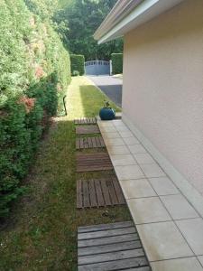 un jardin avec une allée à côté d'une maison dans l'établissement Chambre d hôte, à La Celle-sous-Gouzon