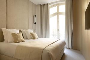 a bedroom with a large white bed with a window at Rive 15 - Appartements Parisiens in Paris