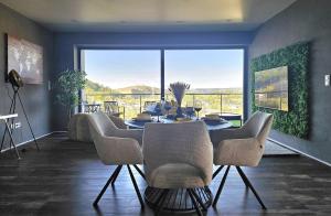 a dining room with a table and chairs and a large window at Traumwohnung mit Sauna Balkon in Bad Berleburg